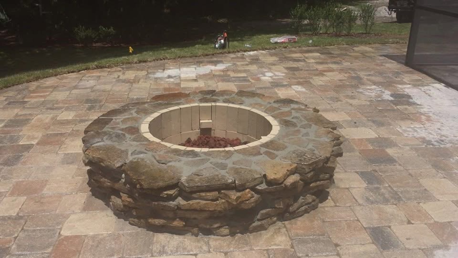 Round stone fire pit on a paver patio