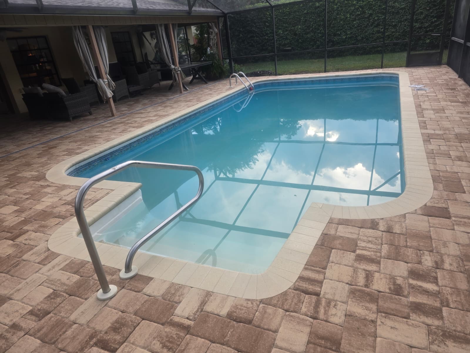 Screened pool deck with warm-toned pavers