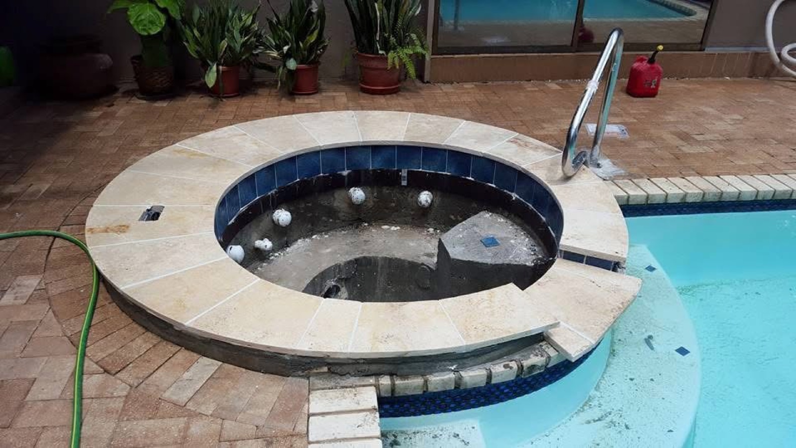 Round spa with travertine coping and blue accent tile