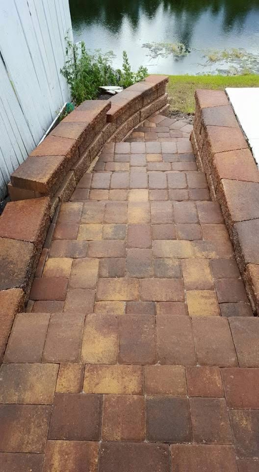 Paver walkway with seat walls leading to the water